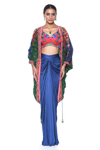 Midnight Jade Green and Deep Red Border Hand Embroidered Shrug, Crimson Cranberry Red Printed Sleeveless Blouse, Oriental Blue Drape Skirt. Crepe and satin gypsy dress and bohemian fashion for cocktail parties, festive gatherings, or resort wear. Designed by Siddharth Bansal.
