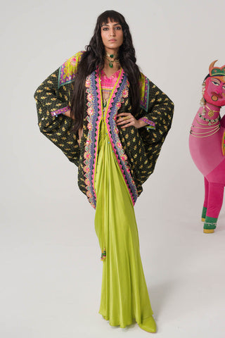 Dark Olive Grove And Neon Pink Border With Hand Embroidered Shrug, Pink Printed Sleeveless Blouse, Neon Pop Green Drape Skirt. Crepe and satin gypsy dress and bohemian fashion for cocktail parties, festive gatherings, or resort wear. Designed by Siddharth Bansal