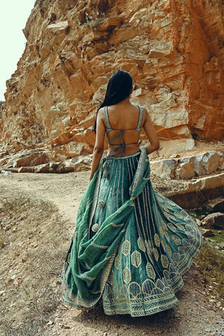 Model posing the back of the lehenga to show the blouse and the dupatta.